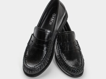 Drei Damenschuhe untereinander: ein beiger Ballerina mit schwarzer Kappe, ein Sneaker mit Leopardenmuster und Schleife sowie ein blauer Loafer. | © Gabor Shoes GmbH, Rosenheim