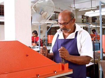 Personen arbeiten an Maschinen in einer Fabrikhalle. | © Gabor Shoes GmbH, Rosenheim