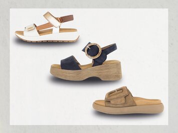 Tre diversi sandali da donna sono visibili su sfondo bianco: in alto un sandalo bianco con cinturini dorati, al centro un sandalo blu scuro con ampia suola in legno e grande fibbia, in basso una ciabatta marrone con suola comoda. | © Gabor Shoes GmbH, Germania