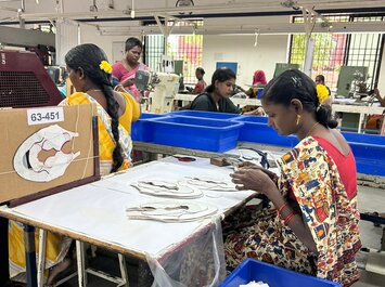 Frauen arbeiten in einer Schuhfabrik und fertigen Schuhteile an einem Arbeitstisch. | © Gabor Shoes GmbH, Rosenheim